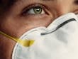 Detailed image of a person's eye and protective face mask, representing health safety.