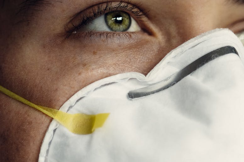 Detailed image of a person's eye and protective face mask, representing health safety.