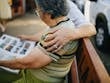 Heartwarming moment with elderly couple reading together while sitting on a bench outdoors.